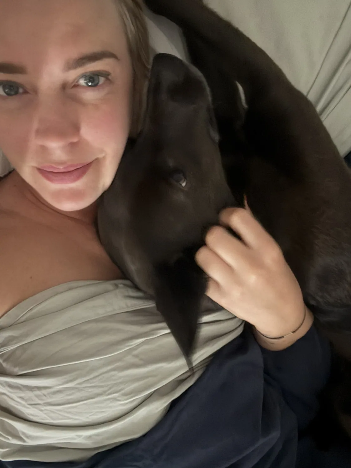 Zoe cuddling a black dog
