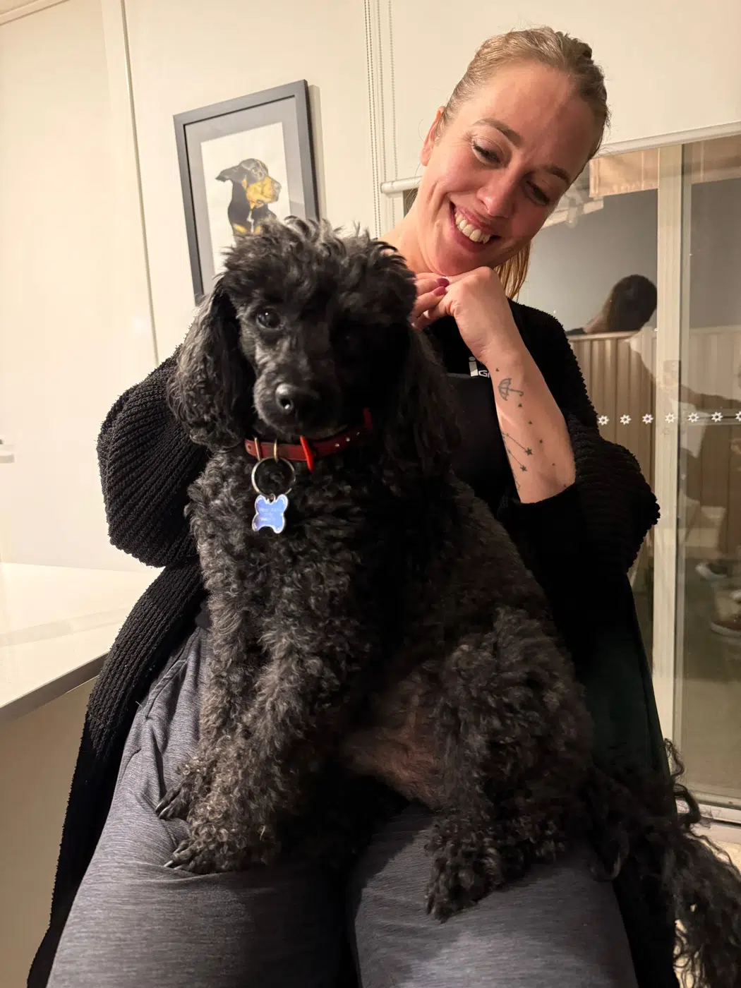 Zoe cuddling a black poodle