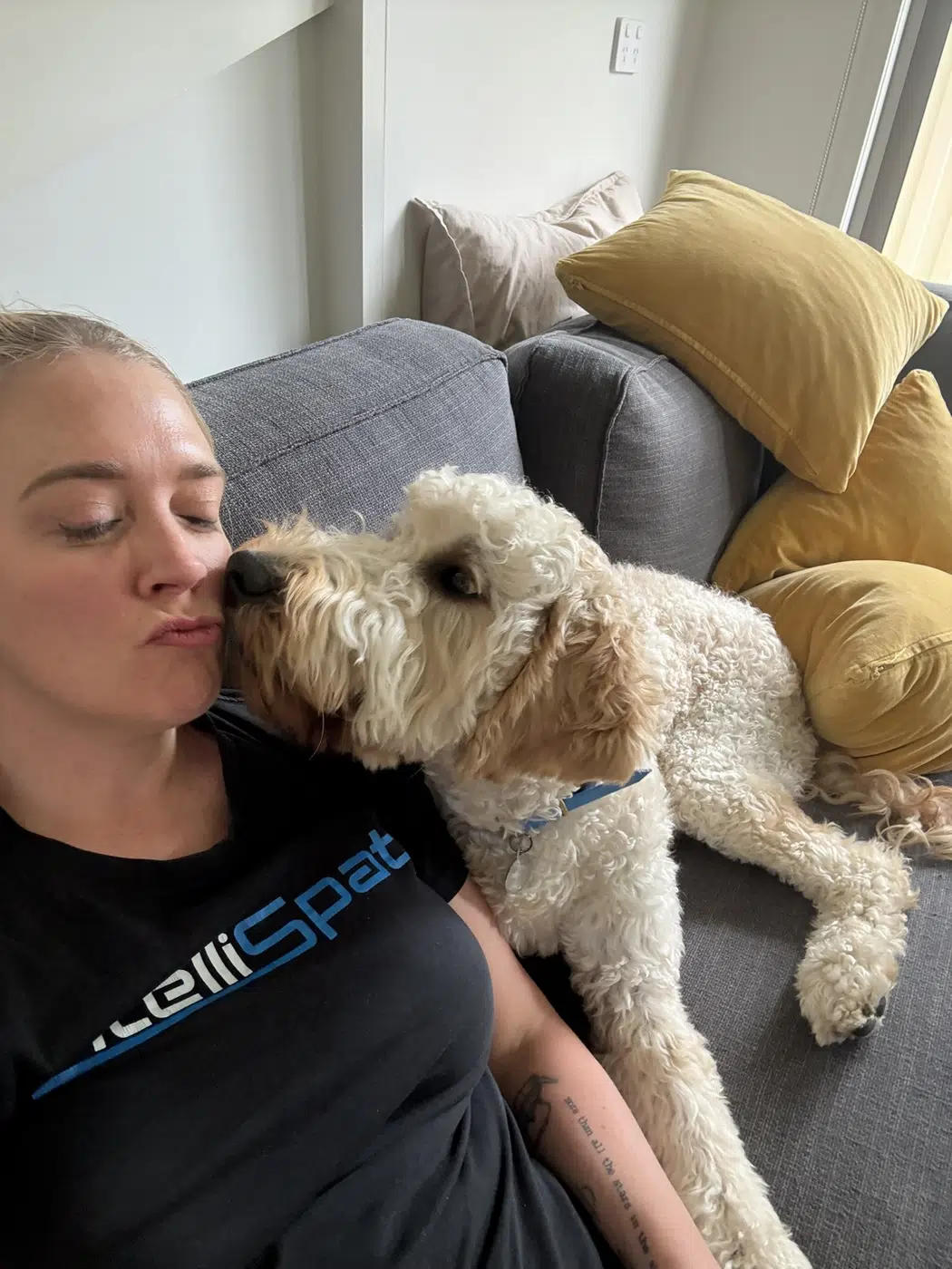 Zoe sharing a cuddle with a curly-haired dog